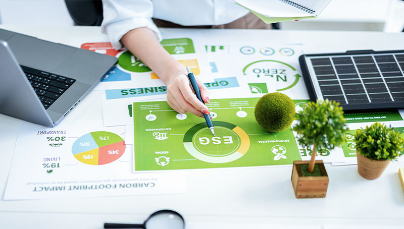 Un professionista analizza documenti su criteri ESG e impatto ambientale per il percorso di sostenibilità di Previdenza Cooperativa.