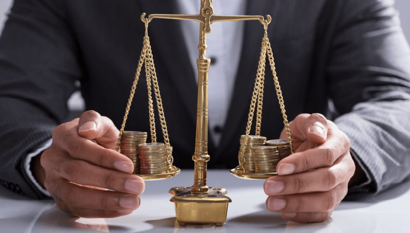 Bilancia con pile di monete, immagine sul confronto dei costi della previdenza complementare